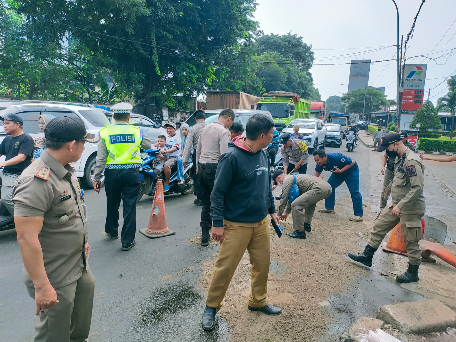 Trantib Kecamatan Jatiuwung bantu atasi tumpahan oli yang berceceran di jalan Gatot Subroto